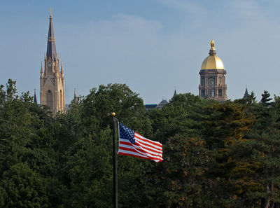 The American flag flies on South Quad in view of the Dome and Basilica.
